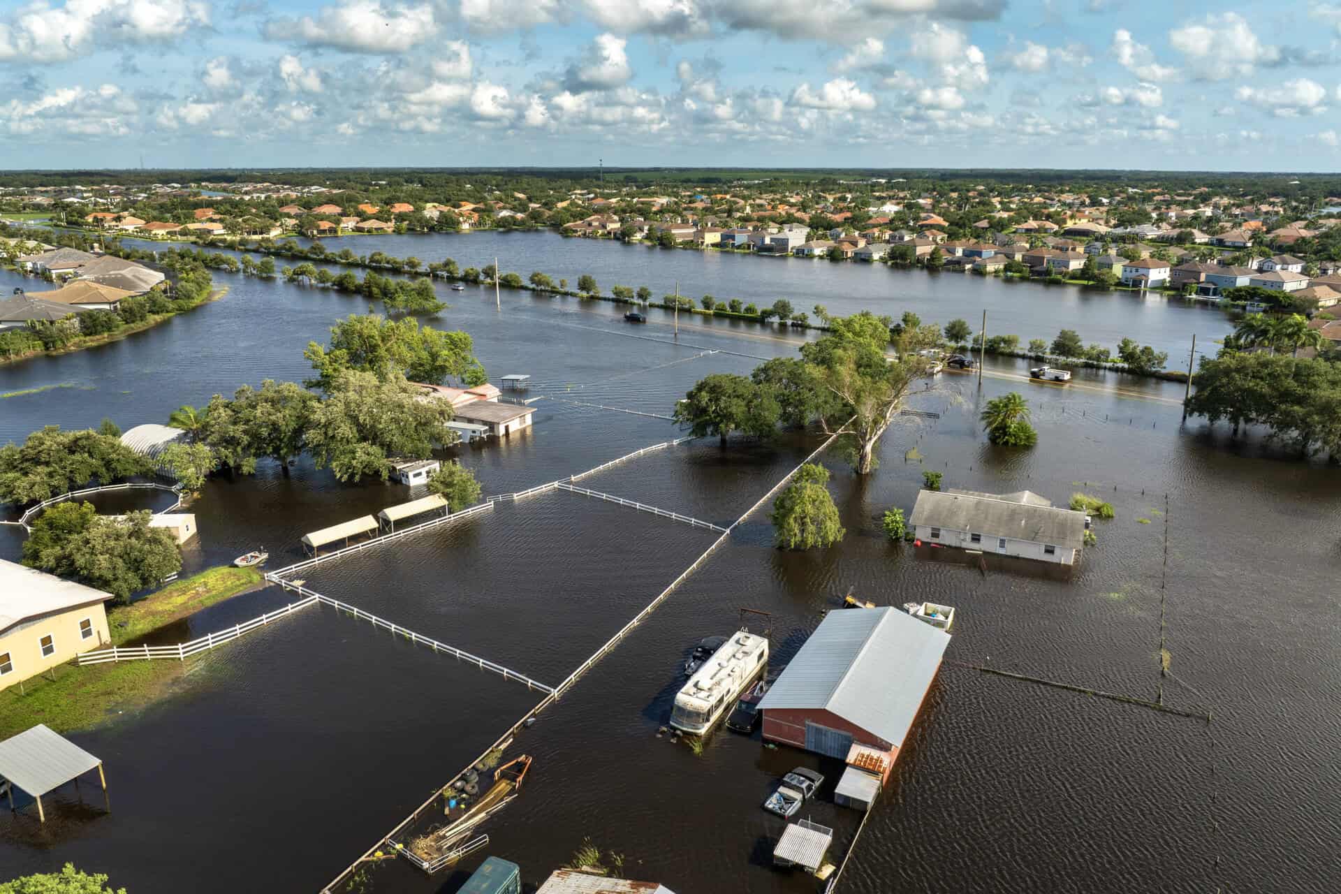 Flooded residential area with water covering streets and properties, highlighting flood risk.