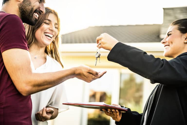 Homeowner receives flood insurance keys from agent outdoors.