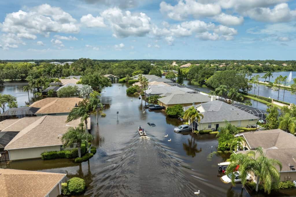 Flooded neighborhood with water covering streets and yards, highlighting flood risk.