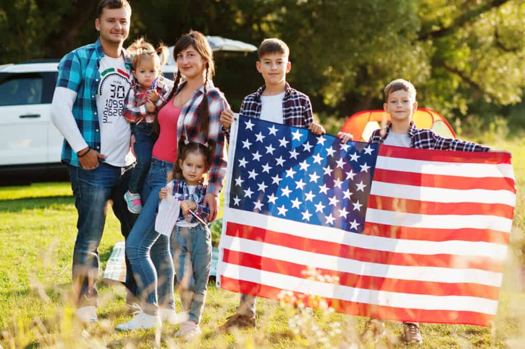 Family standing together with an American flag outdoors